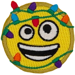 An emoji smiling with an open mouth. It is tangled in multi-coloured Christmas lights.