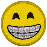 A yellow circle forms a smiley face with smiling eyes and a wide, toothy grin proudly displaying braces.