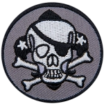 This pirate skull wears an eye patch on its left eye. The skull has two crossed bones and a fleur-de-lis behind it.