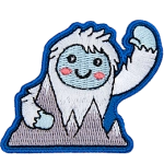 This happy yeti waves a warm welcome as they hold onto the Himalayan Mountains.