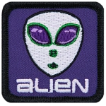 A classic alien head with big eyes and white skin on a purple background. The word Alien is below the head.