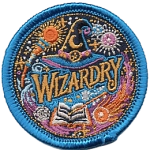 A wizards hat above the word Wizardry, surrounded by spells, a book and a magic wand.