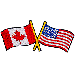 This badge displays the Canadian flag on the left and the United States flag on the right. The flag poles of each flag are crossed with each other.