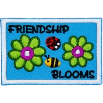 Two green flowers are on either side of a ladybug and bumblebee. The text around them reads Friendship Blooms.