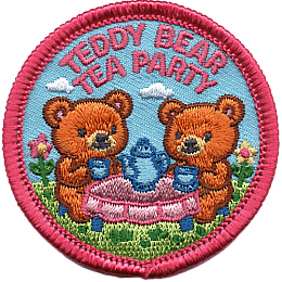 Two teddy bears sit in the grass at a table with a blue tea set.
