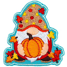 A gnome holds a ripe pumpkin. The gnome is covered in leaves and wears a red and yellow polka-dotted hat.