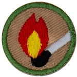 This round one inch badge depicts a lit match.