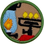 This round one-inch patch depicts a camping lantern and a lit stove.