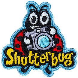 A ladybug holds up a retro camera. The word Shutterbug is stitched across the bottom.  Photography.