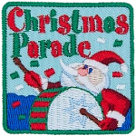 The words Christmas Parade are above a Santa Claus banging a drum.
