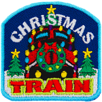 The front of a train is decorated with a wreath and lights. The words Christmas Train are above and below. Two trees frame either side.