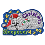 A polar bear snoozes with a Santa hat on his head and a candy cane in his paws.