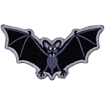 A bat with fangs stares at the viewer. Its wings are outstretched.