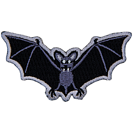 A bat with fangs stares at the viewer. Its wings are outstretched.