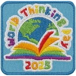 A rainbow book sitting in front of a globe under the words World Thinking Day.