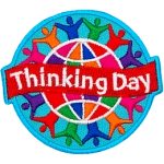 A colourful globe is circled by rainbow-coloured people holding hands. A banner that says Thinking Day is across the middle.