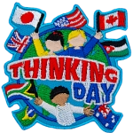 Three cheering people hold up flags of the world on the globe. The words Thinking Day are across the middle.