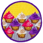 Cupcakes with pink, white and purple icing sit in three rows on a counter.