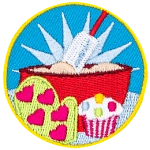 A bowl of batter, an oven mit and a cupcake are in the center of this circular patch.