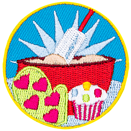 A bowl of batter, an oven mit and a cupcake are in the center of this circular patch.