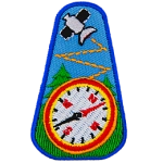 A satellite is above a compass in front of a forest of trees.