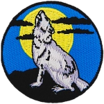 A lone wolf howls at a full moon in this circular patch.