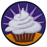 A cupcake with white frosting against a purple background.