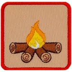 This square badge is part one of a three-part collection that displays a growing campfire. A small yellow flame burns on top of logs in this orange-bordered patch.