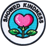 A pink flower in the shape of a heart under the words Showed Kindness. 