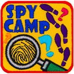 A magnifying glass magnifies a fingerprint. The words Spy Camp are above it, and the right side has shoe prints.