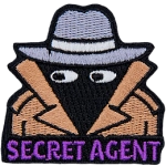 A person wearing a wide-brimmed hat and a brown trenchcoat. The words Secret Agent are across the bottom.