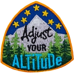 Stars sit above a mountain peak and forest. The text Adjust Your Altitude is in the center of the crest.