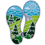 Two boot prints have images of nature within them. From the top down are the sun, clouds, waves, mountains, hills, forest, fields, and bushes.