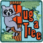 A raccoon hugs a tree with the words Hug A Tree in orange text next to it.