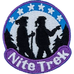 Two silhouettes hike between trees. The words Nite Trek are below them, and the moon is behind them with six stars.