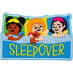 Three little girls are pretending to be asleep in bed. The word Sleepover is across the blanket.