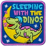 A dinosaur is sleeping on a crescent moon under the words Sleeping With The Dinos.