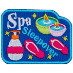 The words Spa Sleepover are between sandals, candles and lotion.