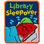 A red book with a green hat is tucked into bed. The words Library Sleepover is above it.