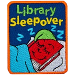 A red book with a green hat is tucked into bed. The words Library Sleepover is above it.
