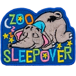 An elephant in his little nightcap sleeps soundly under the stars and the moon. The words Zoo Sleepover are embroidered in a variety of pastel colours.
