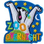 A yawning polar bear waking up from bed with the words Zoo Overnight.