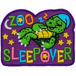 A turtle in his little nightcap sleeps soundly under the stars and the moon - the words Zoo Sleepover are embroidered in various pastel colours.