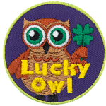 A brown owl with big green eyes holds a four-leaf clover in his wing. The words Lucky Owl is written in yellow near the bottom of the patch.