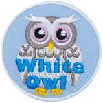 A white owl with big, silver eyes stares right at you. The words White Owl are written in blue at the bottom of the patch.