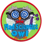 A grey owl wearing a lab coat and crazy glasses holds a purple vial. The words Mad Scientist Owl are across the bottom.