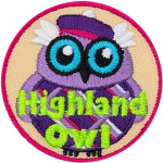 This wide-eyed bird is dressed in a checkered kilt and purple balmoral. The words Highland Owl are embroidered in green stitching.