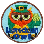 A green owl with a red beard holds a three-leafed clover. The words Leprechaun Owl are across the bottom.