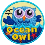 A blue owl is swimming in the ocean. The words Ocean Owl are embroidered at the bottom.
