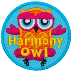 An orange and pink owl sits cross-legged. The words Harmony Owl are across the bottom.